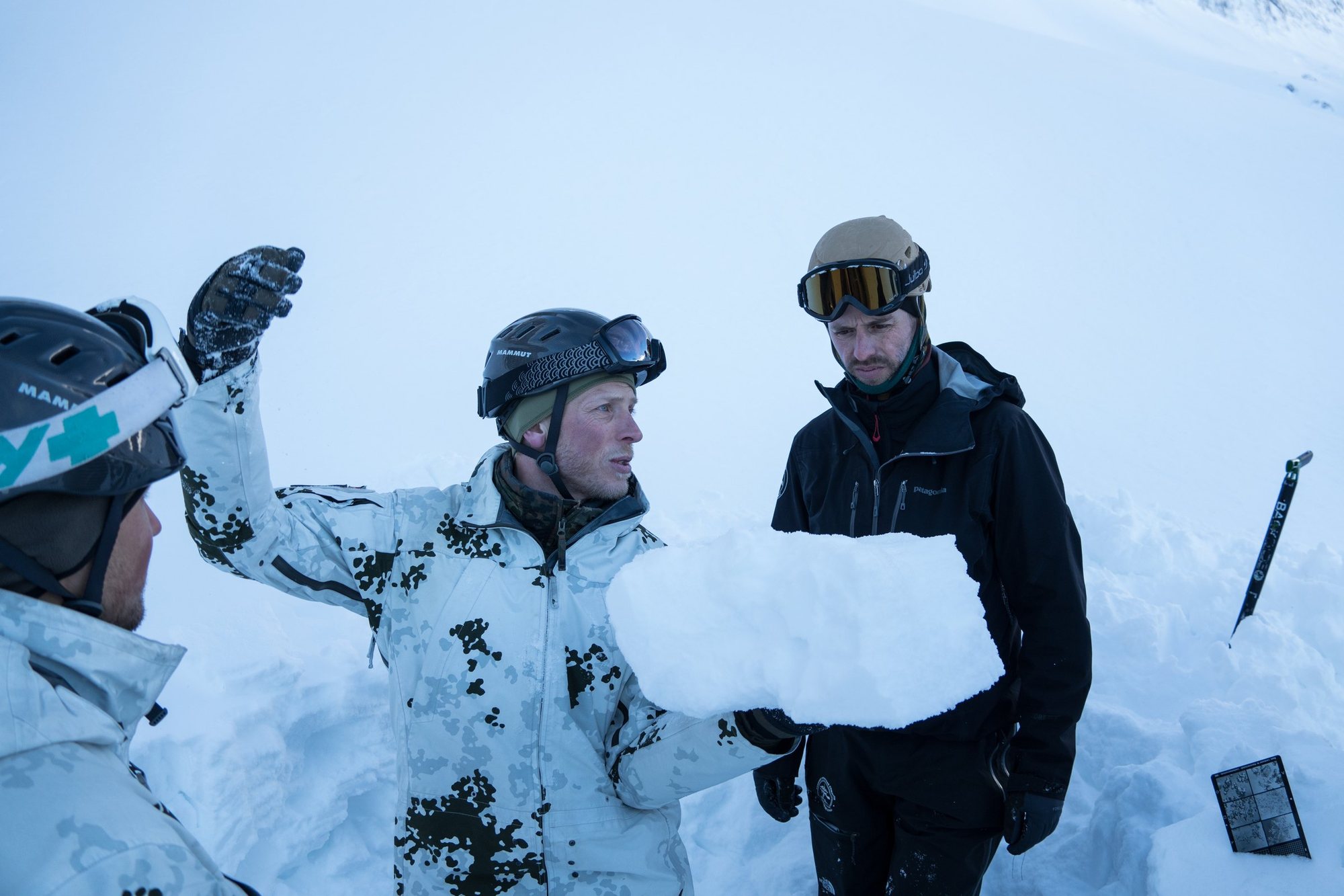 Ein Heeresbergführer erklärt am Schneeprofil die Lawinenlage