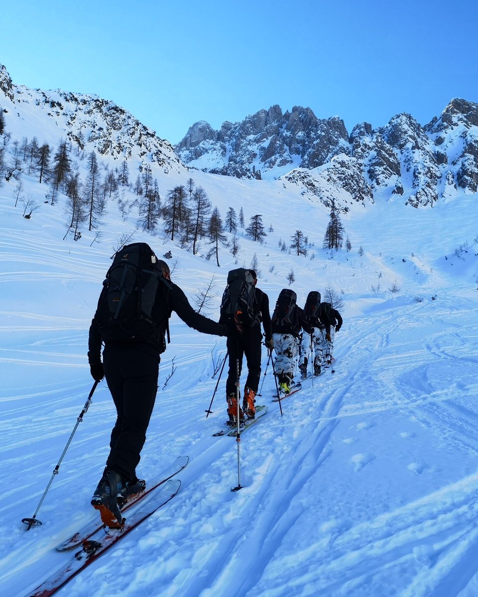 Gruppe auf Skitour im Aufstieg unter blauem Himmel