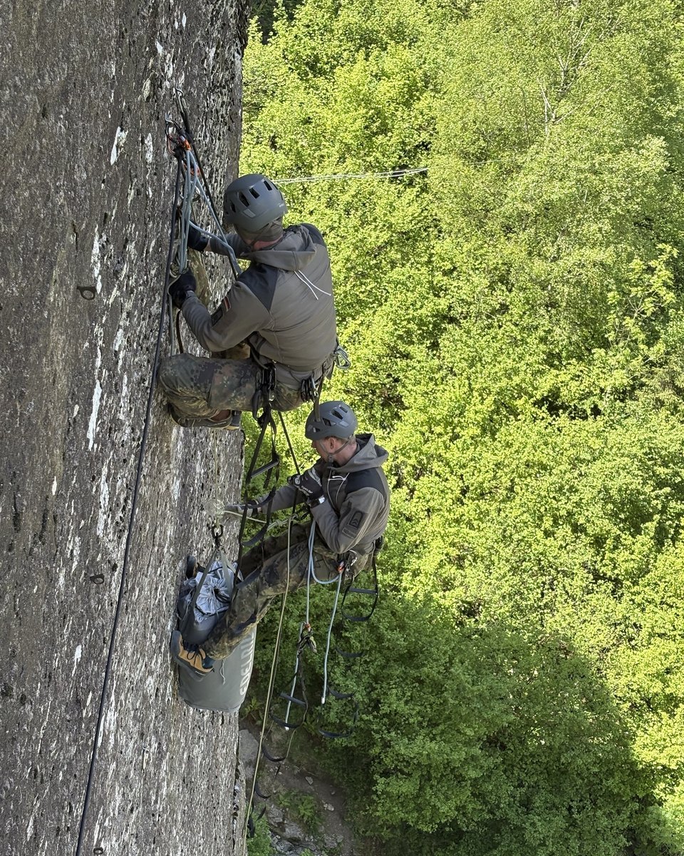 Ausbilder und Soldat übereinander an Trittleitern in der Felswand