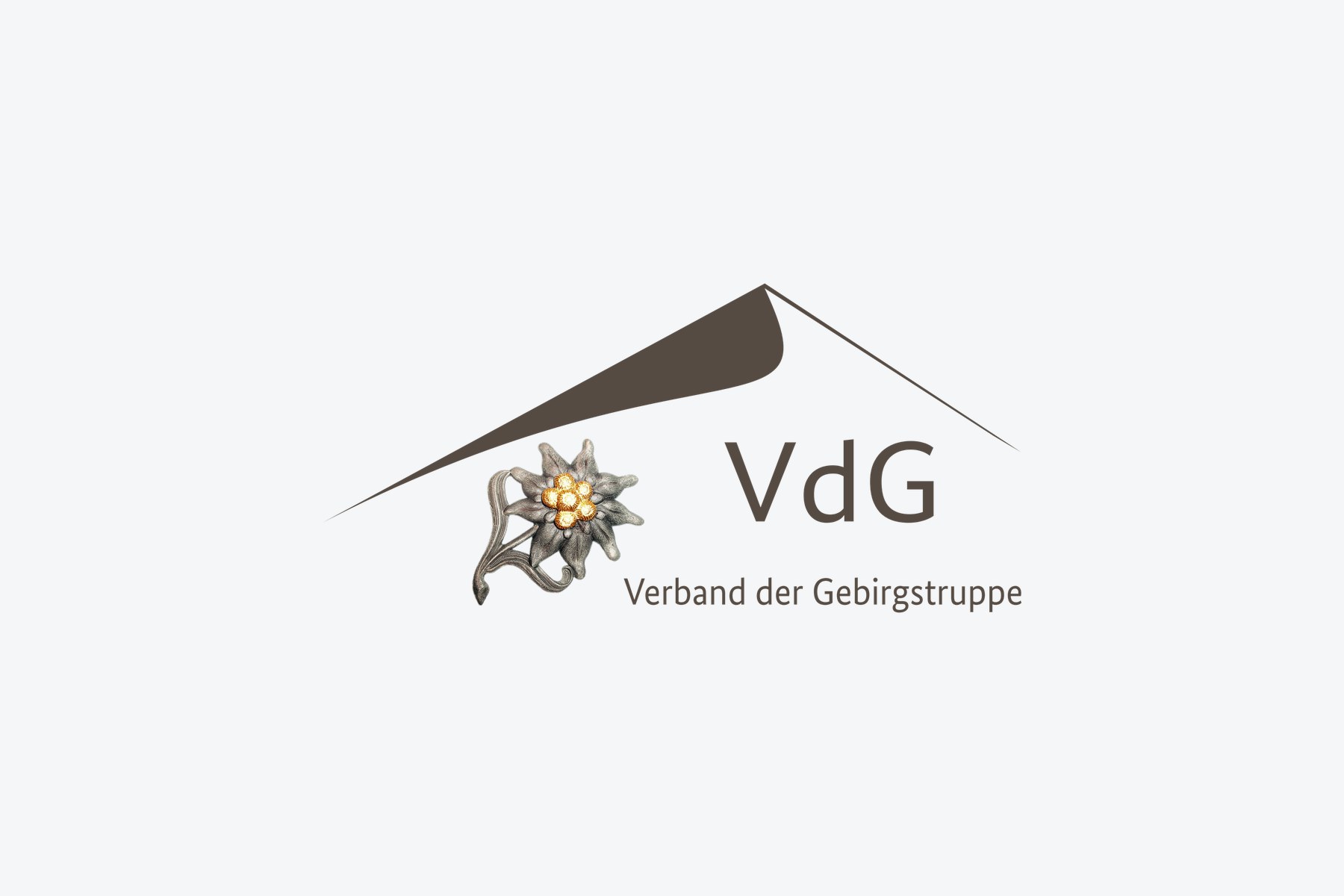 Logo des Verbands der Gebirgstruppe: Edelweiß unter einem Bergdach und der Schriftzug VdG