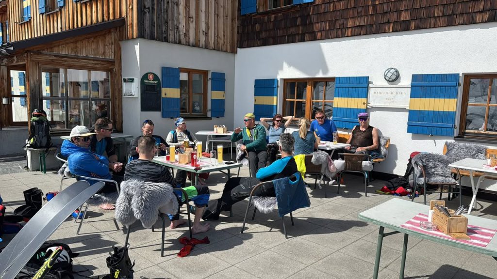 Teilnehmer sitzen in der Sonne auf der Terrasse des Madlenerhauses
